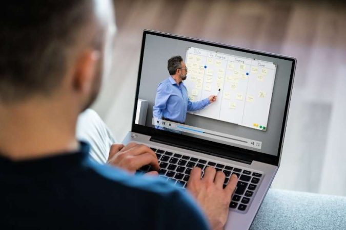 Un salarié utilise son ordinateur portable pour se former au CSE à distance en visionnant un cours en ligne.