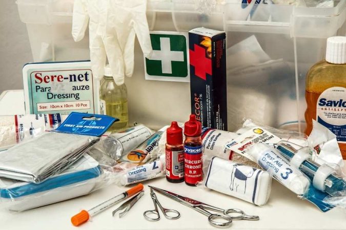 Un étalage complet de matériel médical d'urgence, incluant des bandages, des antiseptiques et des instruments, posé sur une table pour composer une trousse à pharmacie professionnelle.