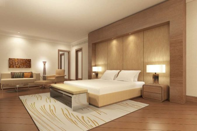 Une chambre spacieuse avec un grand lit king size et des boiseries murales raffinées dans un hôtel de luxe.